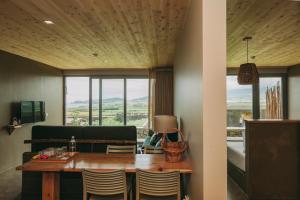 a dining room with a table and chairs and a window at Santa Barbara Eco-Beach Resort in Ribeira Grande