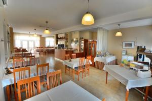 una sala da pranzo e una cucina con tavoli e sedie di Hotel Platan a Székesfehérvár