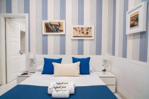 una camera da letto con letto a righe blu e bianche di Napoliviva Bovio a Napoli