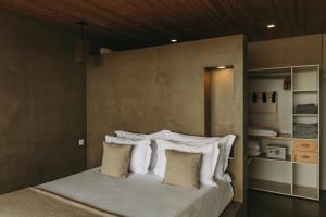 a bedroom with a bed with white pillows at Santa Barbara Eco-Beach Resort in Ribeira Grande