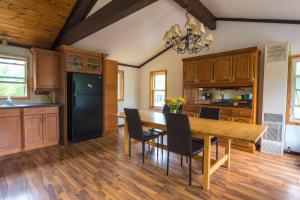 a kitchen with a wooden table and a dining room at Beautiful 3 Bdrm + Bunkie Waterfront Cottage Near Gull Lake in Minden +10 photos