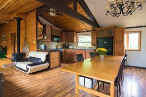 una cucina e una sala da pranzo con tavolo in legno di Beautiful 3 Bdrm + Bunkie Waterfront Cottage Near Gull Lake a Minden