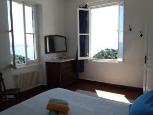 um quarto com uma cama, uma televisão e janelas em Trekking in paradise B&B em Santa Margherita Ligure