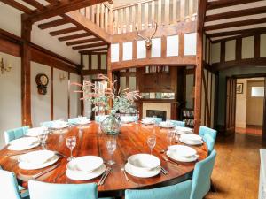 uma sala de jantar com uma longa mesa de madeira e cadeiras em The Chestnuts em Peterborough