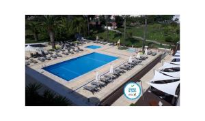 an overhead view of a swimming pool with lounge chairs and a resort at Novotel Setubal in Setúbal
