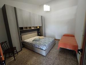 ポルト・コンテにあるAgriturismo da Pinaの小さなベッドルーム(ベッド1台、椅子付)