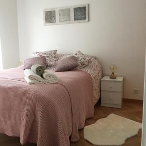 ein Schlafzimmer mit einem rosa Bett mit Handtüchern darauf in der Unterkunft Welcome au Dazzling Stay in Serris