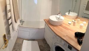 een badkamer met een wastafel en een wasmachine bij Welcome au Dazzling Stay in Serris