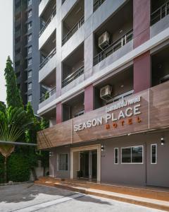 un edificio de apartamentos con un cartel para el hotel sasaki place en Season Place en Bangkok