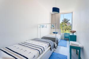 1 dormitorio con 2 camas y ventana en Miguel Bombarda - Porto Houses & Suites, en Oporto