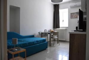 Villino 18 في ماتيرا: غرفة معيشة مع أريكة زرقاء وطاولة