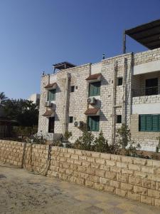 un edificio in mattoni con finestre e un muro di pietra di AL saha2 Basement Chalets villa114 Green Beach a El Alamein