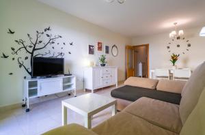 un soggiorno con un divano e una TV di Playa Torrecilla Piscina Centro 2 Habitaciones a Nerja