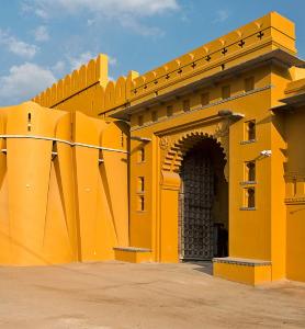 a yellow building with an archway on the side at Gogunda Palace in Udaipur