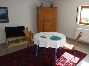 Habitación con mesa, sillas y TV. en Ferienwohnung Haus Edeltraud im Südschwarzwald, grosse, helle, ruhige Souterrain-Whg, Hunde geeignet, mit 2 Fahrrädern, 3 Bäckereien mit Frühstück, 2 Lebensmittel-, 1 Italien-Pastaläden, Kontakt Peter Heubüschl aus Lörrach en Rheinfelden