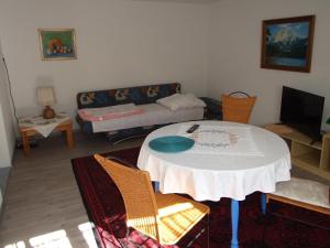 a living room with a table and chairs and a couch at Ferienwohnung Haus Edeltraud im Südschwarzwald, grosse, helle, ruhige Souterrain-Whg, Hunde geeignet, mit 2 Fahrrädern, 3 Bäckereien mit Frühstück, 2 Lebensmittel-, 1 Italien-Pastaläden, Kontakt Peter Heubüschl aus Lörrach in Rheinfelden