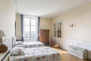 a bedroom with two beds and a window at Paris-sur-seine-chez-caroline in Paris