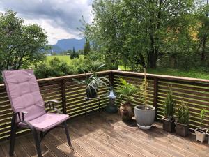 a deck with a chair and potted plants on it at Bed and breakfast in Sauda +3 photos