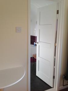 a bathroom with a white door and a sink at Redroofs in Tenbury