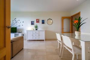 una sala da pranzo con un tavolo e sedie bianche di Playa Torrecilla Piscina Centro 2 Habitaciones a Nerja