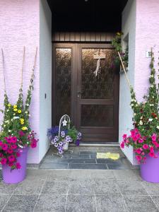 uma porta de uma casa com um banco e flores em Haus Zissi em Burg-Reuland
