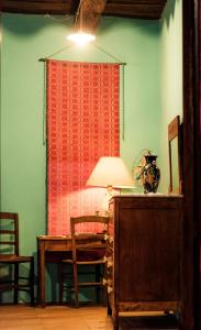 Zimmer mit einem Schreibtisch und einem Tisch mit einer Lampe in der Unterkunft Il Nibbio - La Casa del Vasaio in Morano Calabro