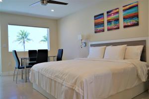 a bedroom with a bed and a table and a palm tree at Diane Oceanfront Suites in Hollywood