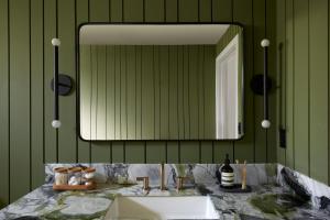 W łazience znajduje się umywalka i lustro. w obiekcie San Luis Creek Lodge w mieście San Luis Obispo