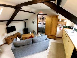 a living room with a blue couch and a bedroom at Coedmor Cottages in Lampeter