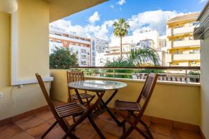balcone con tavolo in vetro e 2 sedie di Playa Torrecilla Piscina Centro 2 Habitaciones a Nerja