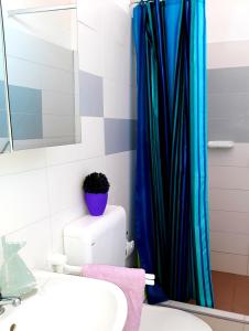 a bathroom with a toilet and a shower curtain at Apartments Luxor in Rogoznica +77 photos