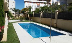 una piscina in un cortile accanto a una recinzione di Playa Torrecilla Piscina Centro 2 Habitaciones a Nerja