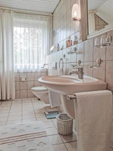 ein Bad mit einem Waschbecken, einem WC und einem Fenster in der Unterkunft Villa Stephan in Extertal
