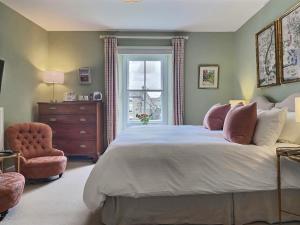a bedroom with a bed and a chair and a window at Grove House in Leyburn
