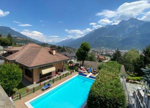 a house with a swimming pool and mountains in the background at Bed & Breakfast Chez Berry in Aosta