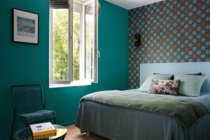 1 dormitorio con paredes verdes, 1 cama y ventana en Un Hôtel En Ville, en La Rochelle