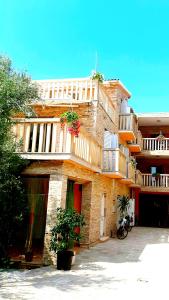 a large brick building with flowers on the balcony at Apartments Luxor in Rogoznica