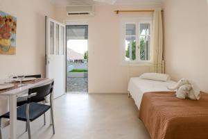 a bedroom with a bed and a desk and a table at Zoumpouli Village in Spartià