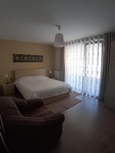 a bedroom with a bed and a couch at Nice apartment with terrace and like view . in Pogradec