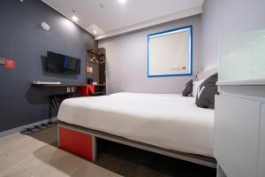 1 dormitorio con 1 cama grande y TV en Seoul N Guesthouse Dongdaemoon, en Seúl