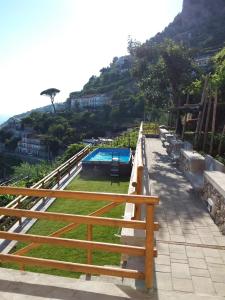 a row of wooden benches next to a swimming pool at San Giacomo Relais in Furore