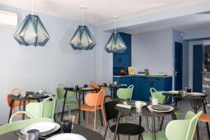 a restaurant with tables and chairs and blue walls at Un Hôtel En Ville in La Rochelle