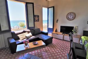 uma sala de estar com um sofá, uma mesa e um relógio em MARISOL SEAVIEW & BEACH - apartment em El Masnou