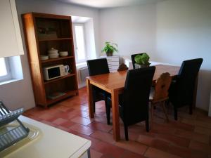 une salle à manger avec une table en bois et des chaises noires dans l'établissement L étoile, à Roussillon