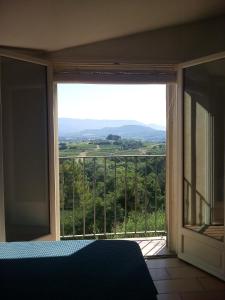 Un dormitorio con una gran ventana con vistas. en L étoile, en Roussillon
