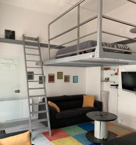 salon z łóżkiem piętrowym i kanapą w obiekcie Gite la Denteliere w Calais