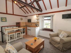 uma sala de estar com um sofá e uma mesa em Kirkcarrion Cottage em Barnard Castle