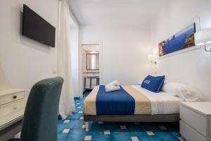 - une chambre avec un lit et une chaise dans l'établissement Marina Grande Residence & SPA, à Sorrente