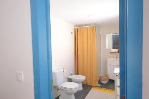 a bathroom with a toilet and a yellow shower curtain at Maria Tereza Sea Villa in Costa da Caparica