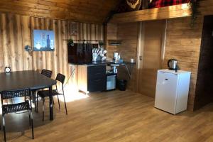 a kitchen and dining room with a table and a refrigerator at Hunter's Lodge in (( Šarlote ))